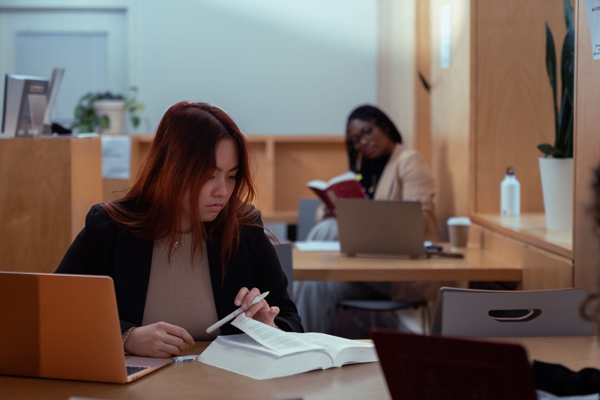 Femmes dans une bibliothèque lisant un document